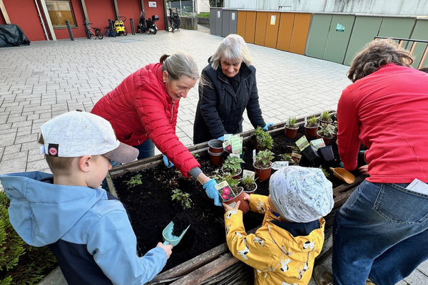 Klein und Groß beim Blumenpflanzen im Hufeland-Haus